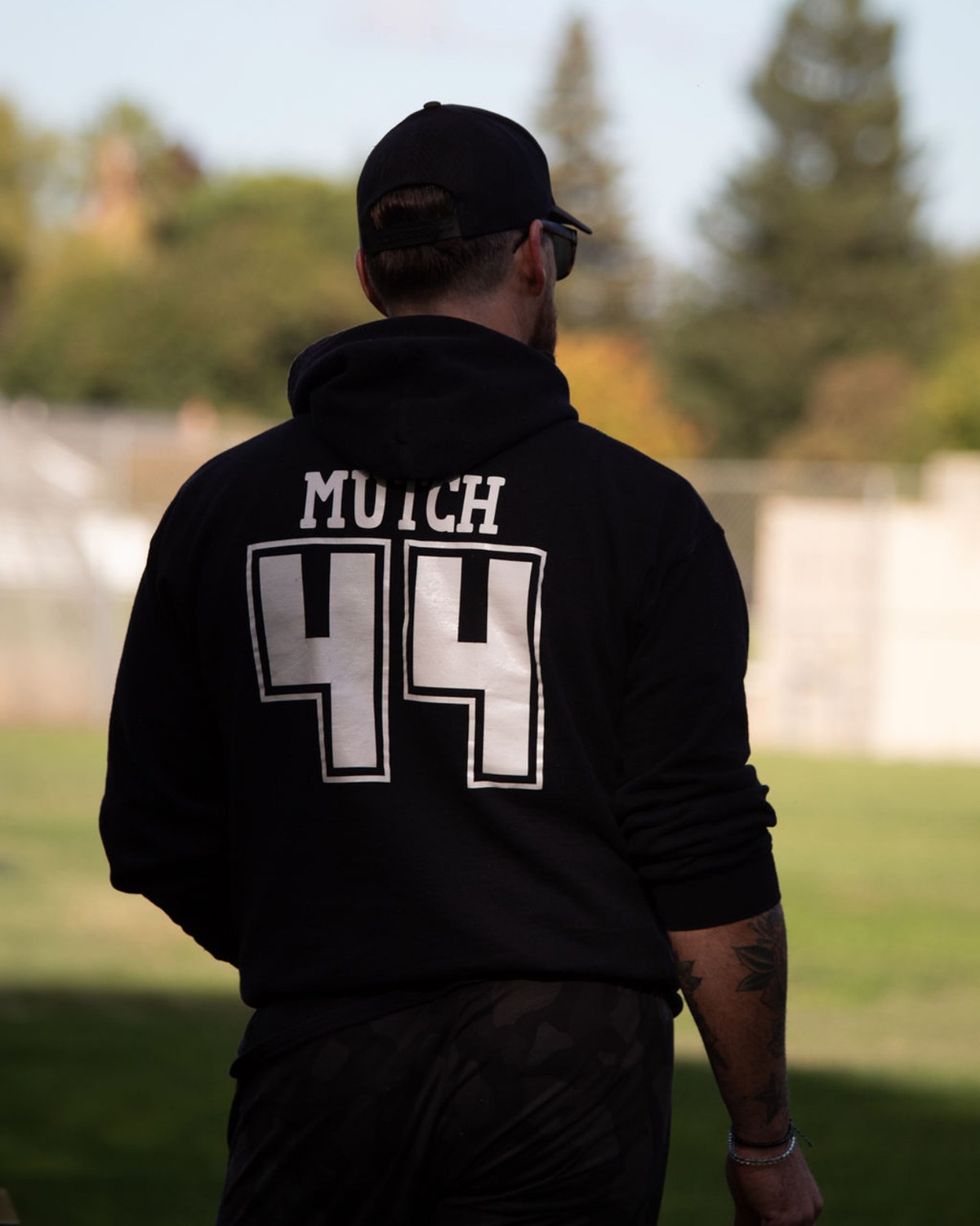 Stephen Mutch walking onto the field in a black MUTCH 44 hoodie.